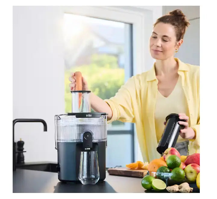 Detailed top view of the 75mm wide feeding chute and pusher accessory on the black Braun MultiJuice 5 centrifugal juicer.