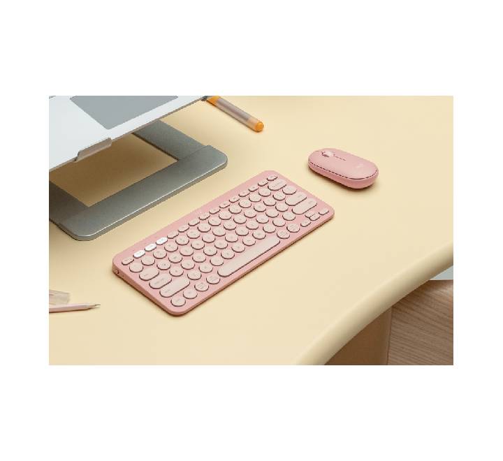 Ergonomic low-profile design of the pink Pebble Mouse 2 silent wireless mouse being used on a clean desk workspace.