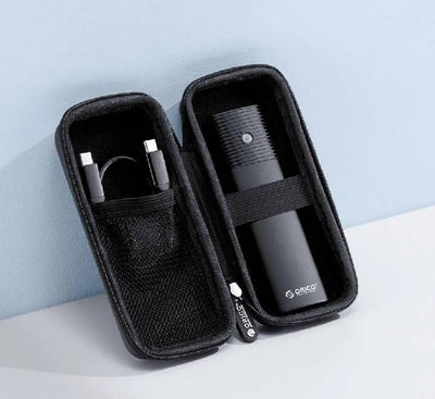 Opened Orico PWFM2 bag displaying structured internal compartments holding an M.2 SSD enclosure, a U disk, and a USB cable.