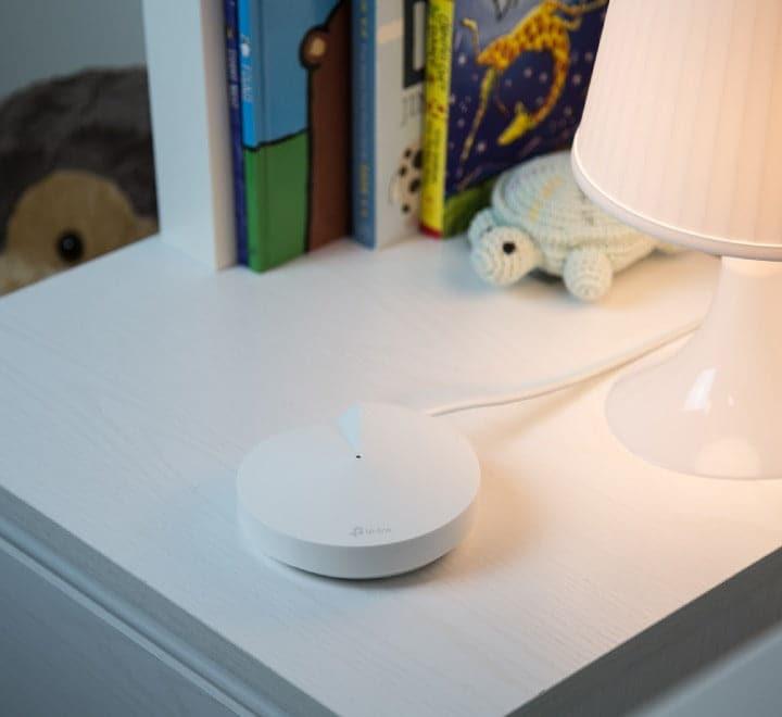 Close-up view of the compact TP-Link Deco M5 unit highlighting its sleek profile and Gigabit Ethernet ports.