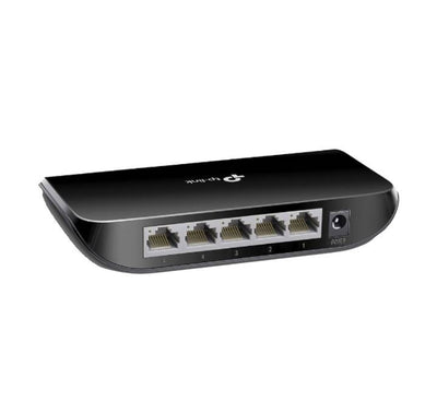 Unboxed view of the TP-Link TL-SG1005D 5-port gigabit switch accompanied by its external power supply cord and installation manual.